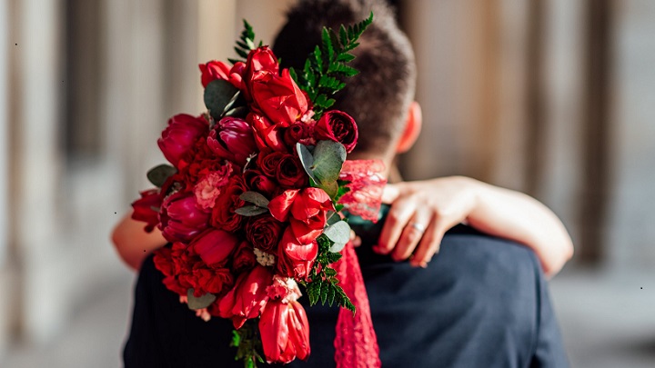 pareja-con-ramo-de-flores-rojas