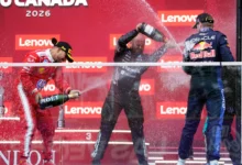 El piloto británico de Ferrari, Lewis Hamilton, el técnico principal de materiales compuestos del equipo Mercedes, Dean Hale, el piloto holandés de Red Bull Racing, Max Verstappen, y el ganador de la carrera, el piloto italiano de Mercedes, Kimi Antonelli