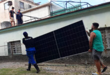 Varios hombres trabajan en la instalación de paneles fotovoltaicos en el exterior de una vivienda, en La Habana. El Estado quiere incentivar que los productores de energía fotovoltaica del sector residencial vendan su excedente a la red eléctrica nacional