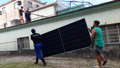 Varios hombres trabajan en la instalación de paneles fotovoltaicos en el exterior de una vivienda, en La Habana. El Estado quiere incentivar que los productores de energía fotovoltaica del sector residencial vendan su excedente a la red eléctrica nacional
